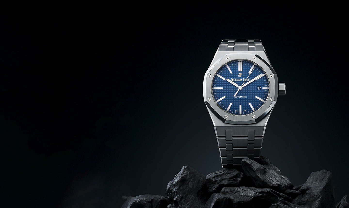 Swiss luxury automatic watch resting on dark volcanic rock